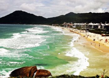 Mar cristalino com ondas perfeitas atrai surfistas e banhistas exigentes.