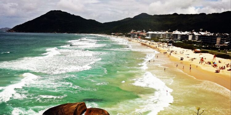 Mar cristalino com ondas perfeitas atrai surfistas e banhistas exigentes.