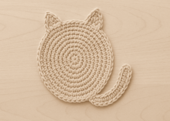 Essa peça de crochê com formato de gatinho deixa a mesa fofa e protegida
