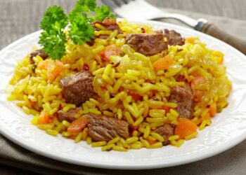 Arroz preguiçoso combina arroz cru, creme de leite, molho de tomate, legumes e proteína em preparo único no forno