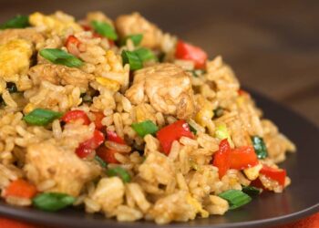 Arroz preguiçoso combina arroz cru, creme de leite, molho de tomate, legumes e proteína em preparo único no forno