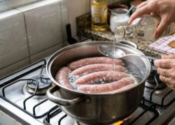 Por que um pouco de vinagre na água do cozimento impede que as linguiças estourem