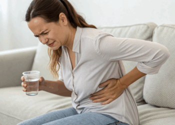 mulher-bebendo-água-mas-com-a-mao-no-rim-com-dor