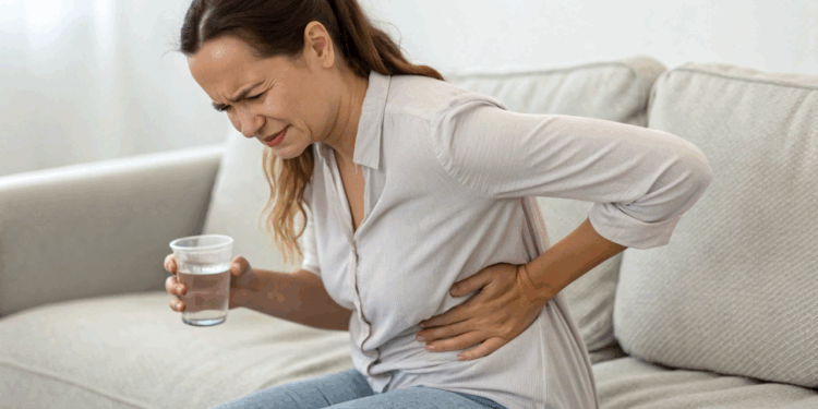 mulher-bebendo-água-mas-com-a-mao-no-rim-com-dor
