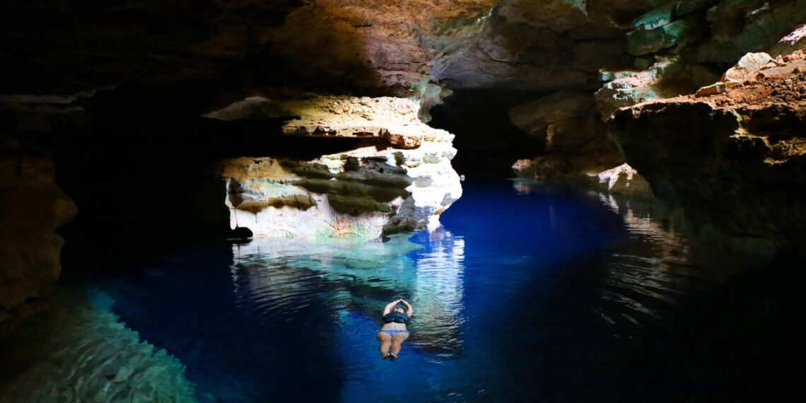 A antiga capital mundial do diamante onde o sol desenha feixes azuis dentro de grutas e guarda cachoeira de 340 metros