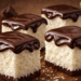 Aprenda a fazer essa sobremesa gelada de maria-mole que combina base cremosa de coco e ganache de chocolate