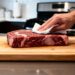 Por que é recomendado secar a carne com papel-toalha antes de levar à frigideira, e como isso é feito?