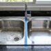 Pia de inox brilhando novamente, sem palha de aço, com uma combinação caseira que remove manchas d’água e marcas de gordura