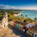 A vila colorida no litoral da Bahia que mistura romaria, praia de água morna e vida noturna animada