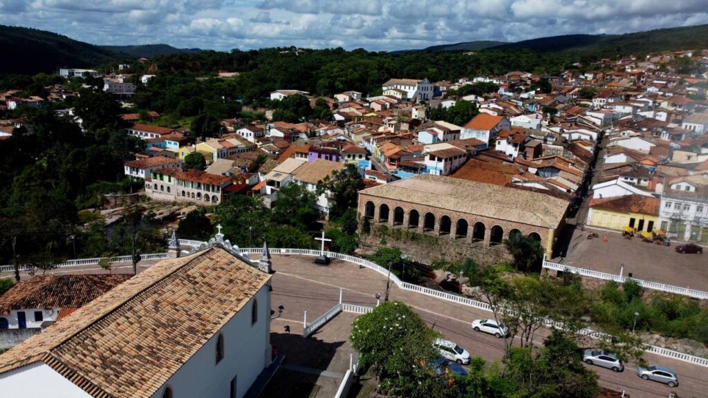 A antiga capital mundial do diamante onde o sol desenha feixes azuis dentro de grutas e guarda cachoeira de 340 metros