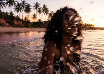 A vila baiana onde os coqueiros formam e a praia espelhada cria fotos perfeitas ao pôr do sol
