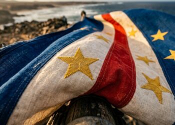 Por que a bandeira de Cabo Verde tem azul, estrelas e faixas coloridas, e qual a origem histórica desses símbolos?