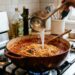 Os melhores chefs concordam: um molho de macarrão perfeito não se faz apenas despejando os tomates na panela; é preciso refogar a base lentamente e adicionar uma concha da água do cozimento da própria massa no final para emulsionar e dar cremosidade