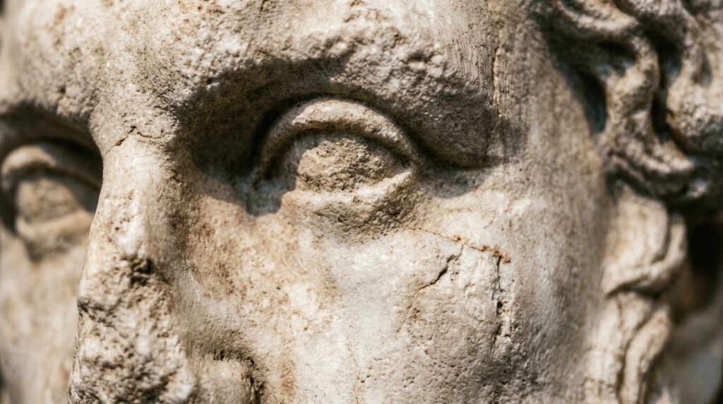 Detalhe em macro das ranhuras e relevos em relevo de um busto antigo esculpido em mármore grego.