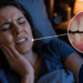 Mulher deitada na cama à noite pressionando o rosto com expressão de dor, com infográficos destacando o desgaste nos dentes e a articulação temporomandibular inflamada em vermelho.