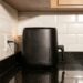 Encostar a air fryer na parede durante o uso pode bloquear a saída de ar quente e aumentar o aquecimento ao redor do aparelho