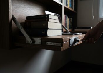 Bancada dobrável de parede instalada em home office com ferragens articuladas aparentes e piso totalmente livre