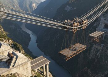 Sistema de cabos transporta enorme peça de aço sobre o cânion.