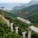 Equipamento de construção viaja suspenso por cabos acima da floresta.