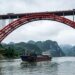 Navio passa sob o vão principal de 575 metros da Pingnan Third Bridge sem pilares intermediários no rio.