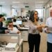 Colegas praticam pequenos gestos de ajuda durante a rotina de trabalho.