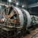 Engenheiros montam uma tuneladora gigante no fundo de um poço.