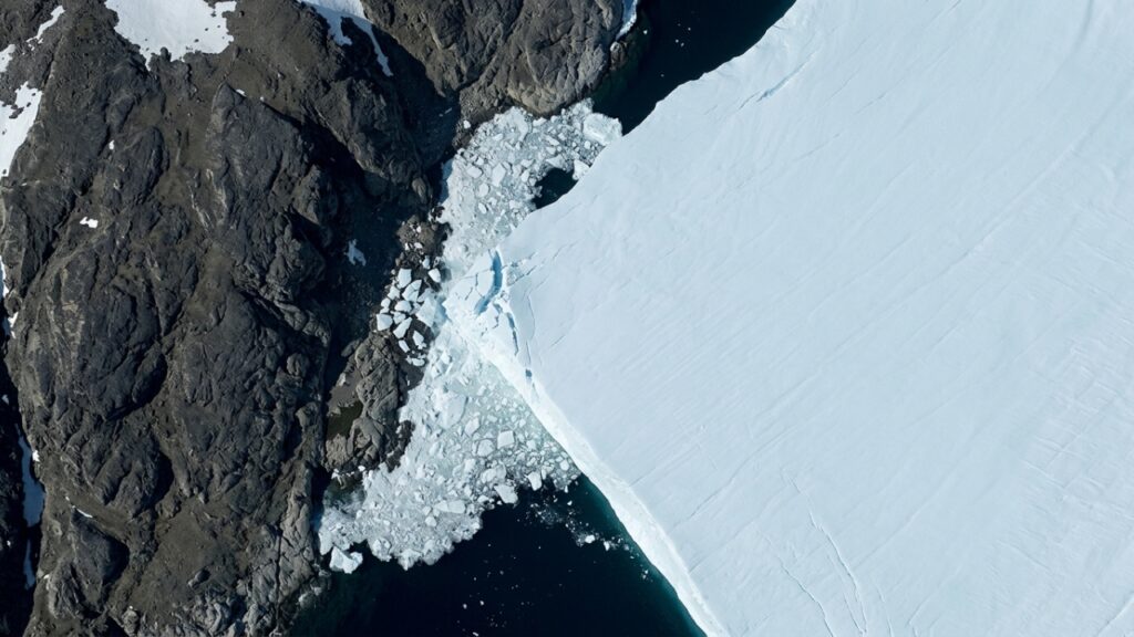 Iceberg_colliding_with_rocky_island_20260914190029-1024x576 Um iceberg de 76 km² se soltou da Groenlândia, percorreu o fiorde, bateu em uma ilha rochosa e surpreendeu cientistas ao continuar praticamente inteiro