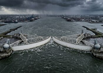 Barreiras da Maeslantkering giram sobre o canal para fechar a passagem durante uma tempestade.