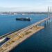 Vista aérea panorâmica da ligação de Øresund mostrando a ponte estaiada descendo na ilha artificial de Peberholm e mergulhando no túnel submarino.