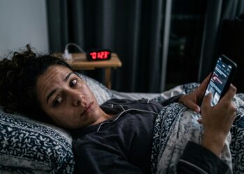 Pessoa cansada continua rolando vídeos no celular enquanto uma representação de Aristóteles remete ao conflito entre julgamento e ação.
