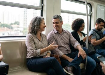 Dois desconhecidos conversam durante uma viagem de transporte público.