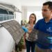 Técnico retira filtro coberto de poeira de um ar-condicionado split para realizar a limpeza.