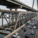 Trem e carros ocupam lados diferentes do pavimento inferior da Ponte Changtai.