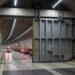 Enorme porta de segurança fecha uma seção de um túnel rodoviário para isolar determinada área.