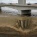 Corte de uma ponte mostra o concreto intacto acima da água e o solo erodido ao redor da fundação submersa.