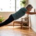 Pessoa com mais de 60 anos realiza flexão na parede em casa com postura controlada.