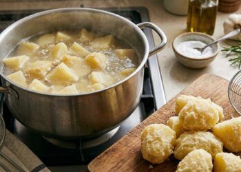 Batatas cozinham em água com pequena quantidade de bicarbonato e desenvolvem uma superfície mais áspera antes de ir ao forno.