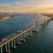 Projeção aérea da Ponte Salvador–Itaparica atravessando a Baía de Todos-os-Santos, com pilares marítimos e trecho central sustentado por cabos de aço.