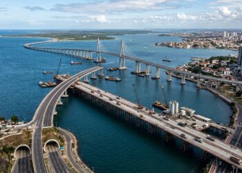 Plataforma provisória sobre o mar recebe caminhões e máquinas durante a construção da ponte.