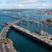 Plataforma provisória sobre o mar recebe caminhões e máquinas durante a construção da ponte.