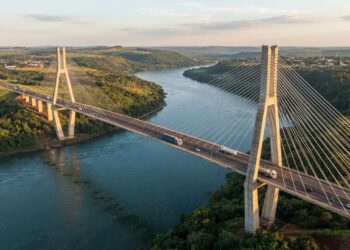Vista aérea ilustrativa da Ponte da Integração sobre o Rio Paraná, mostrando duas torres de concreto, cabos de aço e o longo vão central entre Brasil e Paraguai.