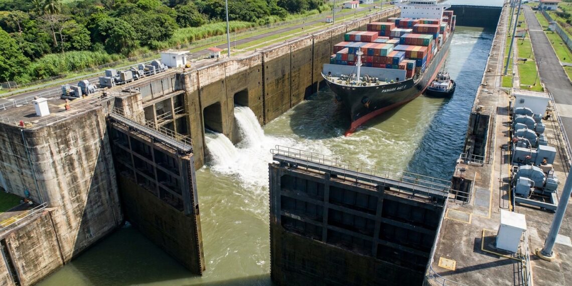 Navio cargueiro flutuando dentro de uma eclusa do Canal do Panamá durante a elevação do nível da água.