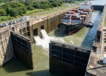 Navio cargueiro flutuando dentro de uma eclusa do Canal do Panamá durante a elevação do nível da água.