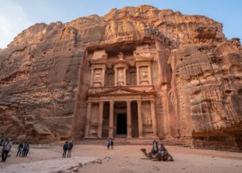 Fachada monumental do Tesouro de Petra esculpida diretamente em um paredão de arenito na Jordânia.