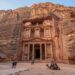 Fachada monumental do Tesouro de Petra esculpida diretamente em um paredão de arenito na Jordânia.