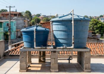 Caixas-d’água residenciais de 500 e 1.000 litros instaladas em uma área técnica de uma casa.