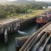 Navio de grande porte dentro de uma câmara de eclusa enquanto o nível da água é ajustado para permitir sua passagem pelo canal.