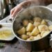 Batatas pré-cozidas são chacoalhadas na panela para criar uma superfície irregular antes de ir ao forno.