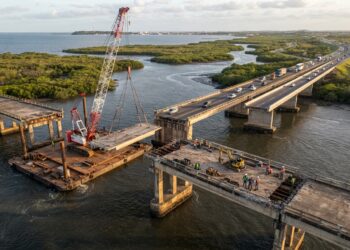 Representação aérea da desmontagem de uma ponte de concreto no Estreito dos Mosquitos, com guindaste e ponte paralela em operação na BR-135.