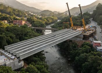 Vista inferior de uma ponte de concreto sobre o Rio Piabanha, mostrando vigas apoiadas em encontros nas margens e o vão livre sobre a água.